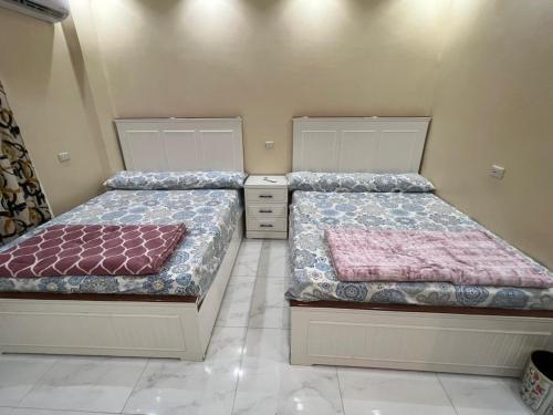two beds sitting next to each other in a room at شاليه الفهدي in Sphinx International Airport