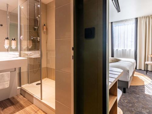 a bathroom with a shower and a bed and a sink at Mercure Beaune Centre in Beaune