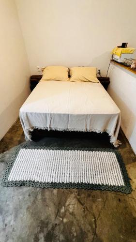 a bedroom with a bed with a white comforter at Kitnet charmosa a 4 min da praia in Porto Seguro