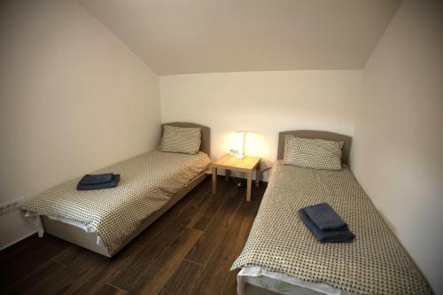 two beds in a small room with a table at Familija in Belgrade