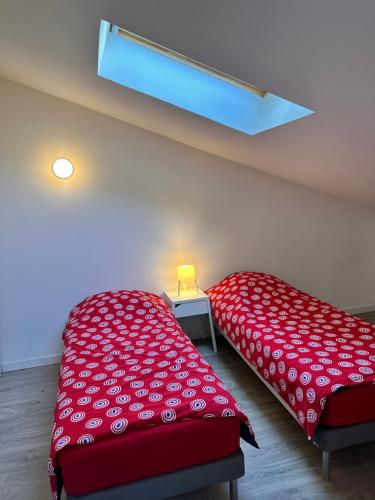a room with two beds with a red bedspread at LOFT, MAISON de VILLE de 100m2, 7 lits in Bagnolet