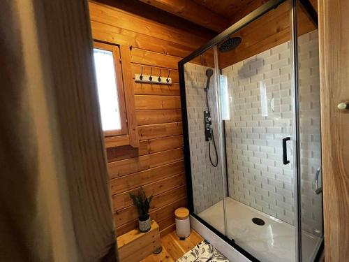 a bathroom with a shower with a glass shower stall at Cottage relaxant au bord de l'eau in Bourbourg