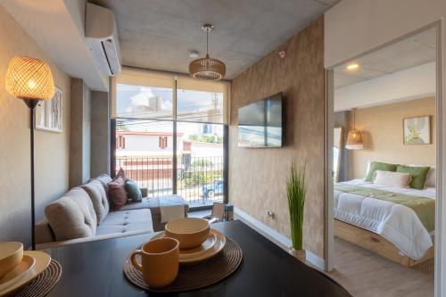 a bedroom with a bed and a living room at Babylon Prime Nunciatura in San José