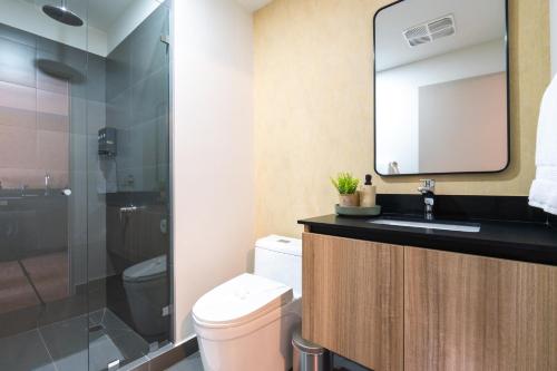 a bathroom with a toilet and a sink and a shower at Babylon Prime Nunciatura in San José