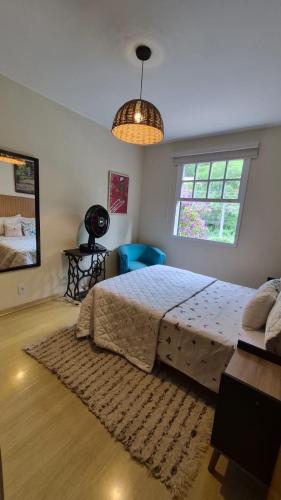 a bedroom with a large bed and a window at duplex aconchegante com varanda em condominio in Nova Friburgo