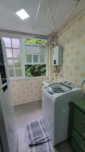 a bathroom with a washing machine and a sink at duplex aconchegante com varanda em condominio in Nova Friburgo