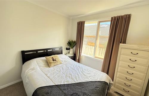 a bedroom with a bed with a pillow and a window at ABC Homes Nedlands in Doncaster East