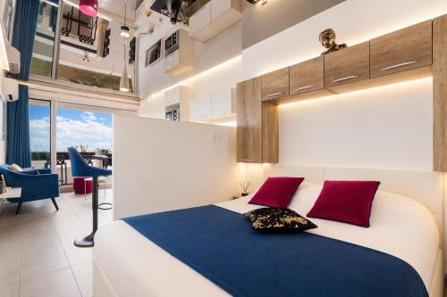 a bedroom with a large white bed with red pillows at Le Bocca Port Nature - Vue mer - coursive - Parking - Clim - Village Naturiste in Cap d'Agde