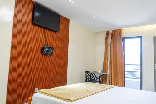 a bedroom with a bed and a television on a wall at Résidence Madior D2 in Dakar
