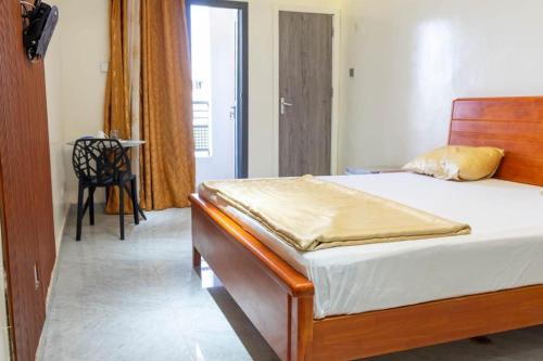 a bedroom with a bed and a table and a chair at Résidence Madior D2 in Dakar