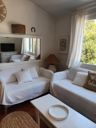 a living room with a couch and a bed at Casa Mo in Cala en Bosc