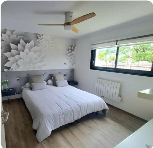 a bedroom with a white bed and a ceiling fan at Maison cosy in Grésy-sur-Aix