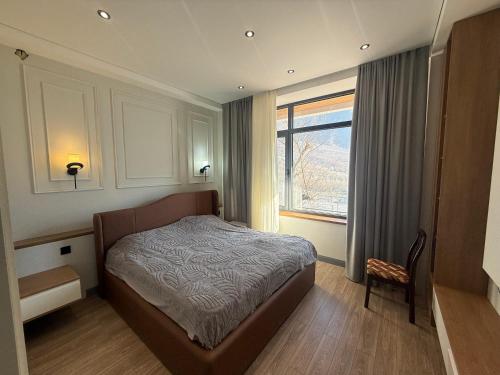 a bedroom with a bed and a window and a chair at Mountain sight Villa in Sheki