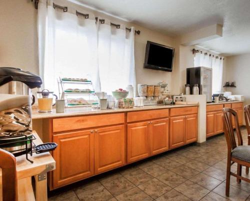a kitchen with wooden cabinets and a large window at Urban Inn & Suites in Boise