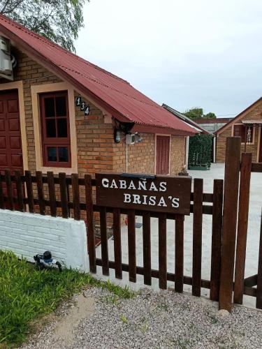 a sign on a fence in front of a house at Cabañas Brisa's in Santa Vitória do Palmar