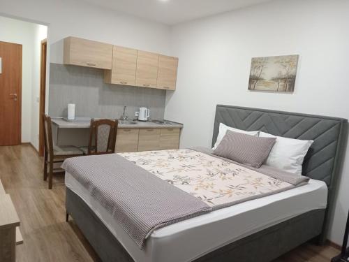 a small bedroom with a bed and a kitchen at Apartments Karić Aerodrom Tuzla in Dubrave Gornje