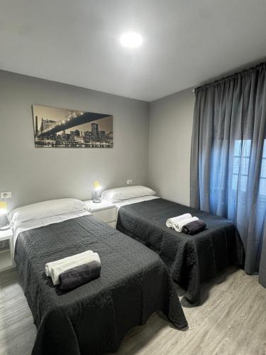 a bedroom with two beds with towels on them at PASEO CASCO ANTIGUo in Lugo