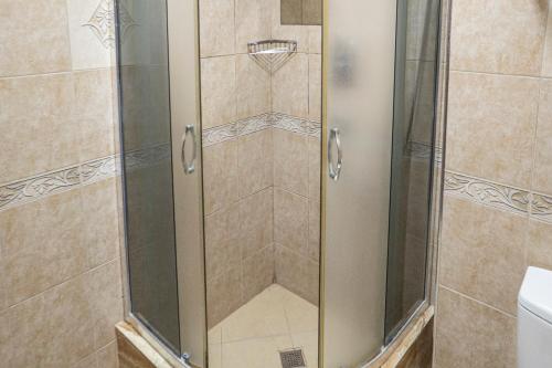 a shower with a glass door in a bathroom at Hotel Cameo in Kvariati
