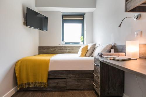 a bedroom with a bed with a desk and a window at For Students Only - Queen's Court Reading in Reading