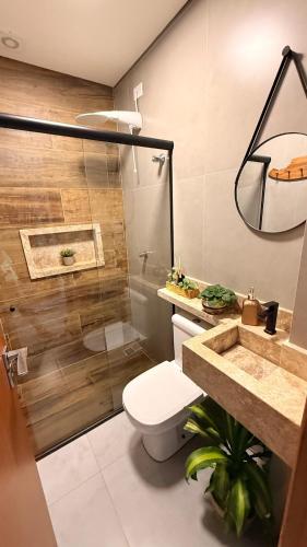 a bathroom with a shower and a toilet and a sink at Flat aconchegante em Juquehy! Com piscina! in Praia de Juquehy