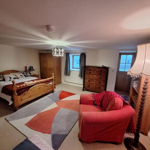 a bedroom with a bed and a chair and a couch at Parciau barn in Clyro