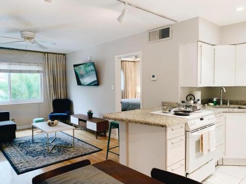 a kitchen and living room with a counter and a table at Galleria Apartments By Lowkl in Fort Lauderdale