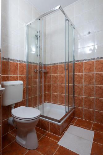 a bathroom with a toilet and a glass shower at Fritz Holiday in Siófok