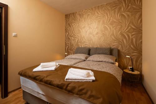 a bedroom with a bed with two towels on it at Fritz Holiday in Siófok
