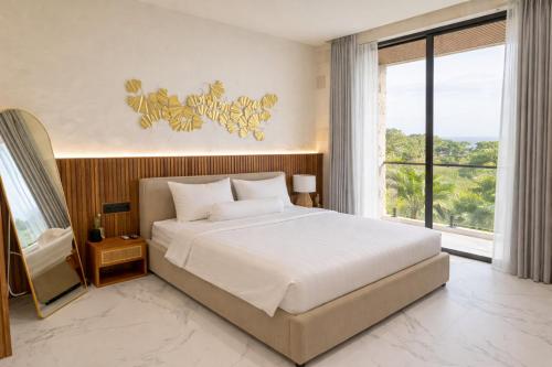 a bedroom with a large bed and a large window at White Residence by Iji in Uluwatu