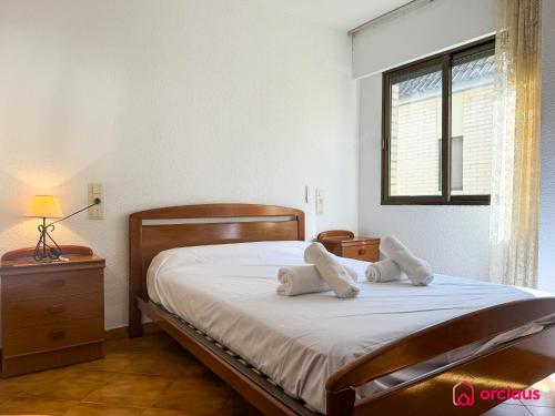 a bedroom with a bed with white sheets and a window at Poble Mar 8 in Oropesa del Mar