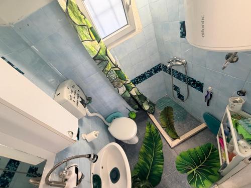 a bathroom with a sink and a shower with plants at Laniakea small apartment in the house in Risan in Risan