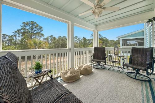 a screened in porch with two chairs and a table at Salt & Pine in Pensacola