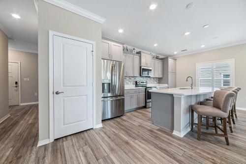 a kitchen with white cabinets and a large island at Salt & Pine in Pensacola