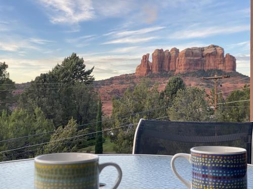 two cups on a table with a view of a mountain at Perfect Couples Getaway Private Hot Tub Panoramic Red Rock Views in Sedona