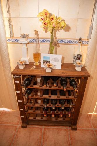 a table with a bunch of wine bottles and a vase at A Casa do Olival in Mealhada