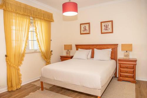 a bedroom with a white bed and a window at A Casa do Olival in Mealhada
