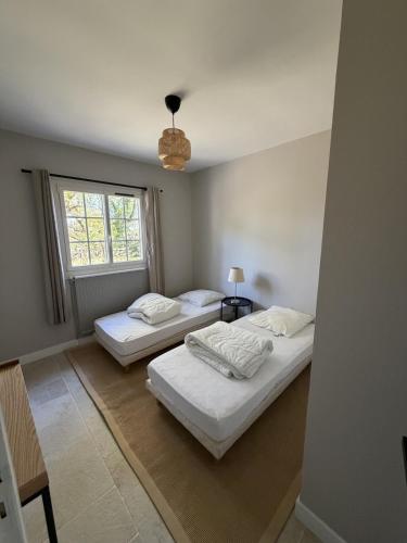 two beds in a room with a window at Bask'aise o Pyla in La Teste-de-Buch