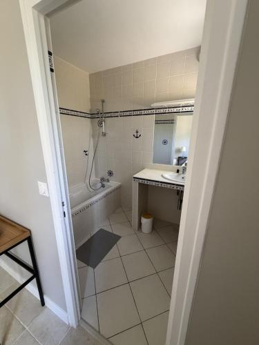 a bathroom with a tub and a sink and a bath tub at Bask'aise o Pyla in La Teste-de-Buch