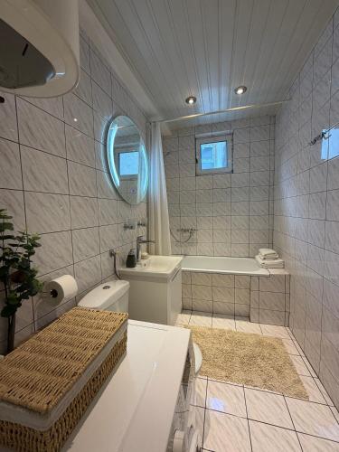 a bathroom with a tub and a toilet and a sink at Perla Sea View in Budva