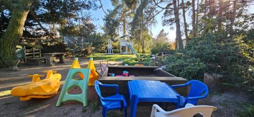 a play area with a table and chairs and a playground at Chata u Hřiště in Loučeň