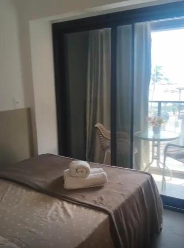 a towel sitting on a bed in front of a mirror at VISTA MAR SPOT Barra in Salvador