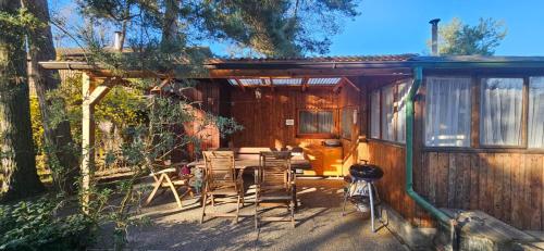 a patio with chairs and a table in a cabin at Chata u Hřiště in Loučeň