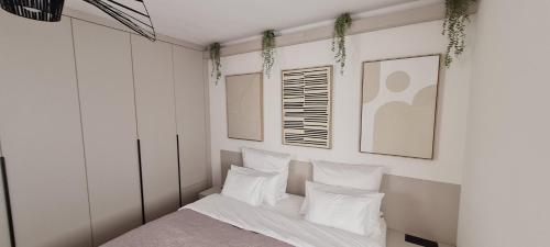 a bedroom with white walls and a bed with white pillows at Vila VivaVir with 2x E-Scooter, private Pool & Grill in Vir