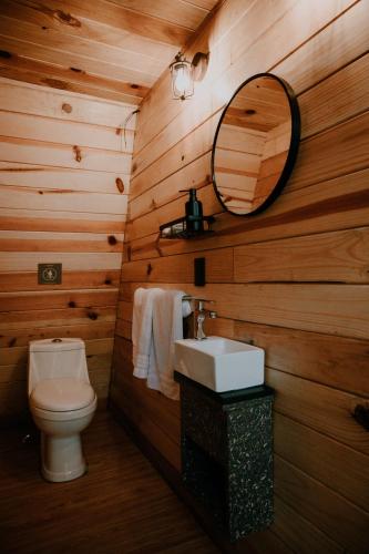 a wooden bathroom with a toilet and a mirror at WANDER CABIN La Marquesa in La Marquesa