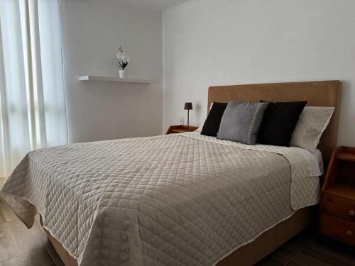 a white bedroom with a large bed with pillows at Apartment in Lima JM in Lima