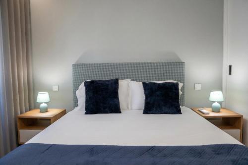 a bedroom with a large bed with two lamps at RS Porto Central Apartments in Porto