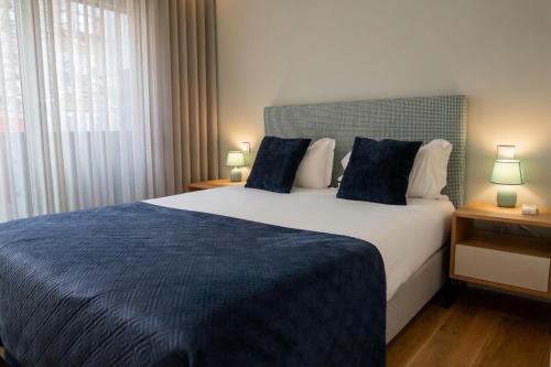 a bedroom with a large bed with a blue blanket at RS Porto Central Apartments in Porto