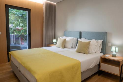 a bedroom with a large bed with a large window at RS Porto Central Apartments in Porto