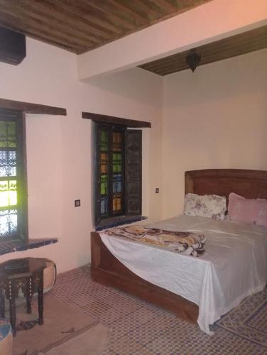 a bedroom with a bed and a table and windows at Esc 6 3 9 in Fez