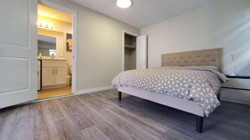 a white bedroom with a bed and a bathroom at Meet Cottage in Vancouver